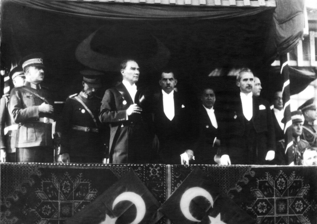 Atatürk 1933 onuncu yıl töreninde tribünde, önde bayraklar