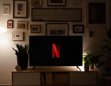 Karanlık bir oturma odasında ekranında Netflix logosu görünen televizyon